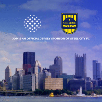 A city scape of Pittsburgh with the logos of JDP and Steel City FC