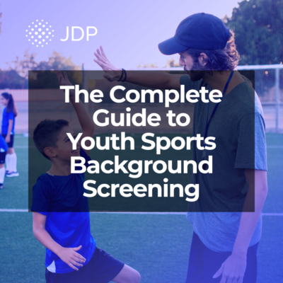 A youth sports coach giving a high five to a youth athlete.